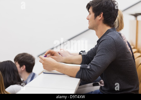 Student sitting in a lecture hall and listening the teacher Stock Photo