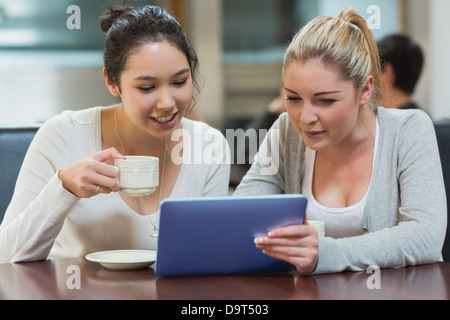 Two students in a coffee shop using a tablet pc Stock Photo