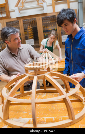 Teacher and a student in a woodworking class working on a frame Stock Photo