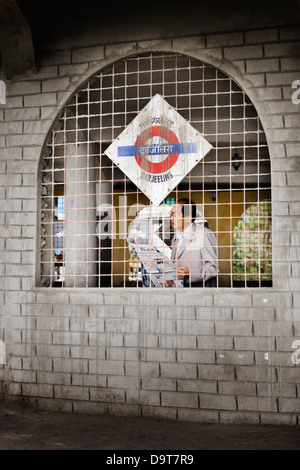 Man reading newspaper at the Darjeeling Railway Station, West Bengal, India. Stock Photo