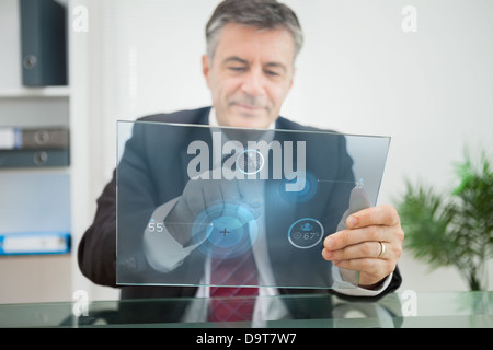 Businessman using futuristic touchscreen to view statistics Stock Photo