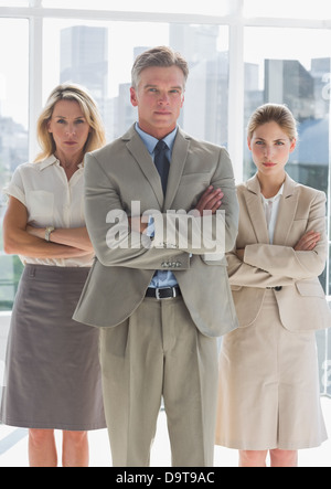 Three serious business people standing together Stock Photo - Alamy