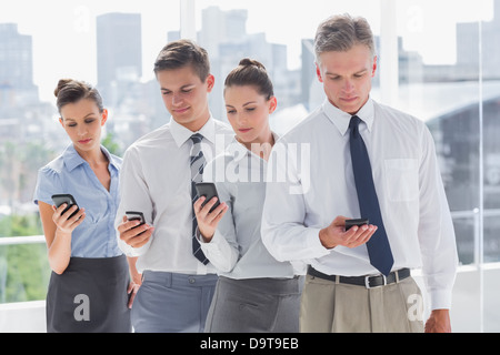 Serious business people standing together Stock Photo - Alamy