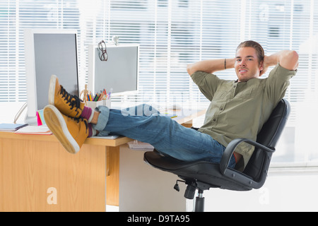 Designer relaxing with foot on the desk Stock Photo