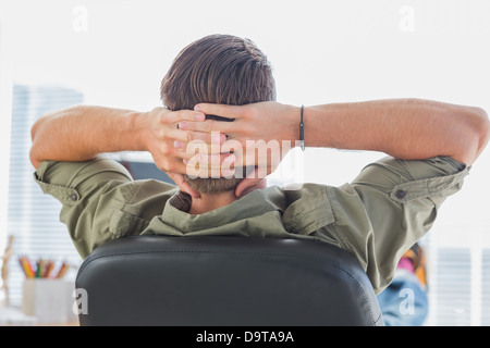 Rear view of a designer relaxing with foot on the desk Stock Photo