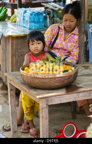 Fruit Seller with little Girl in the rural Kampot Province of Cambodia Stock Photo