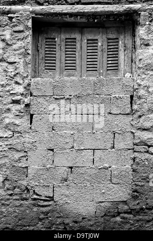 Bricked up window and textured wall abandoned house exterior. Black and white. Stock Photo