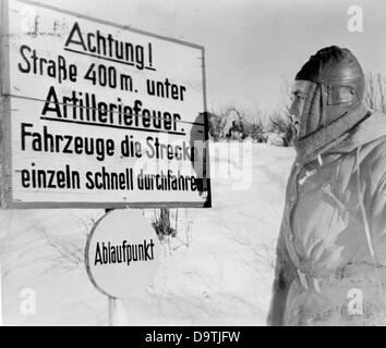 The Nazi Propaganda! on the back of the image reads: 'Warning sign on the street right at the front.' ('Attention! Street 400 meters under artillery fire. Vehicles drive through one at a time and fast.') Image from the Eastern Front, 26 February 1943. The attack on the Soviet Union by the German Reich was agreed on in July 1940 and prepared as the 'Operation Barbarossa' since December 1940. On 22 June 1941, the invasion by the German Wehrmacht started. Fotoarchiv für Zeitgeschichte Stock Photo