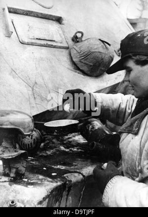 Propaganda text of National Socialist report on the back of the picture:  'Fried eggs on the tank used as table'. Motive from the Eastern front on the 25th of March in 1941. In contrast to the information provided in Germany, supplies were rare at the Eastern front.       Fotoarchiv für Zeitgeschichte Stock Photo