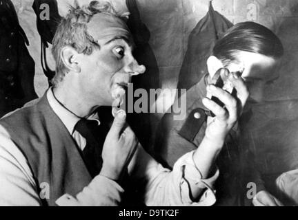 A soldier dresses up as a clown for a performance on the Eastern Front, published 19 January 1943. The Nazi Propaganda! on the back of the image reads: 'Soldiers entertain soldiers. A corporal puts the finishing touches on his make-up of a clown. The red wig, snub nose, everything is at the right spot, only a little more make-up and the act can be presented!' Fotoarchiv für Zeitgeschichte Stock Photo