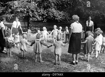 Girls of the German Girls League (BDM) take care of children in a children's home of the National Socialist People's Welfare (NSV), in September 1939. Fotoarchiv für Zeitgeschichte Stock Photo