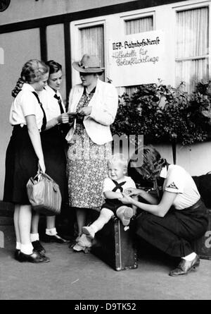 Girls of the German Girls League (BDM) help travelling women and children at the hitchhiker station in Berlin, in August 1939, in the station service of the National Socialist People's Welfare (NSV). Fotoarchiv für Zeitgeschichte Stock Photo