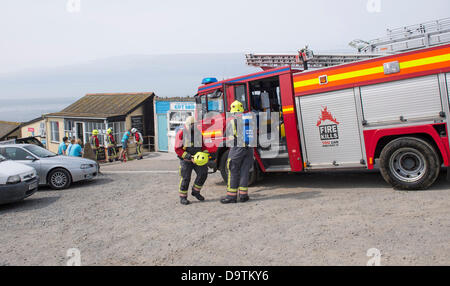 Electrical Fire at  Polpeor cafe fire fighters and engine in attendance, smoke damage can be seen on the wall of the cafe Stock Photo