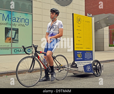 Young man on a bicycle advertising for the New York Health & Racquet Club gym. In the East Village of New York City Stock Photo