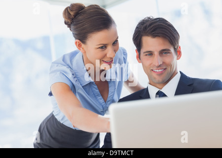 Happy business people looking together at the laptop Stock Photo