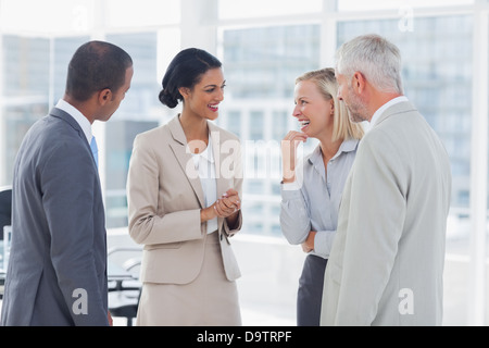 Happy business team chatting and laughing Stock Photo