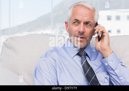Thoughtful businessman calling on smartphone Stock Photo
