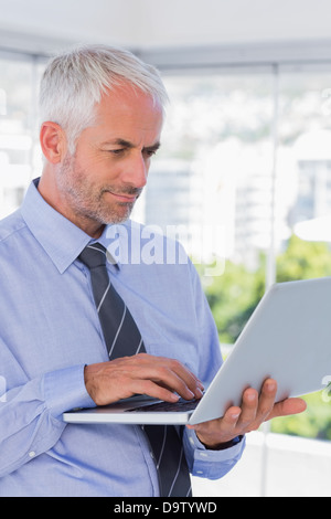 Businessman standing and using laptop Stock Photo