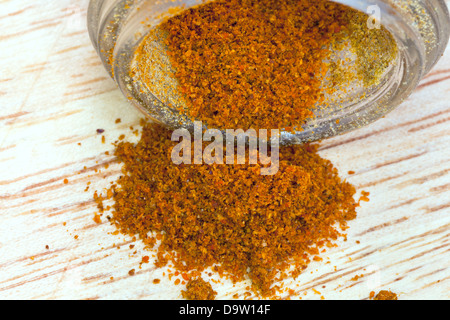 ground cayenne pepper heap from glass jar close up Stock Photo
