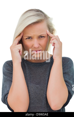 Woman with headache touching her forehead and looking at camera Stock Photo