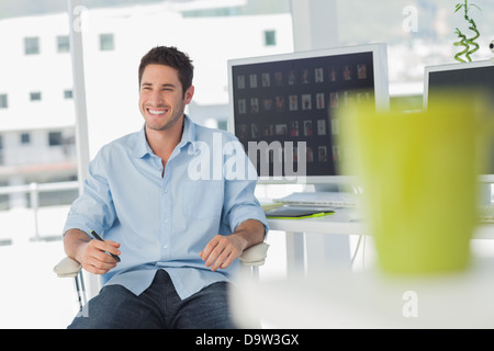 Cheerful photo editor in his swivel chair Stock Photo