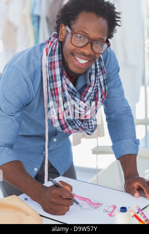 Smiling creative designer drawing clothes Stock Photo
