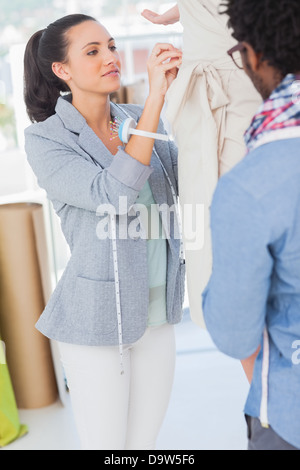 Two fashion designers adjusting dress Stock Photo - Alamy
