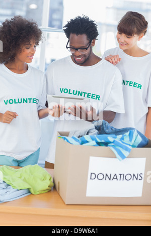 Cheerful volunteers looking at a tablet pc Stock Photo