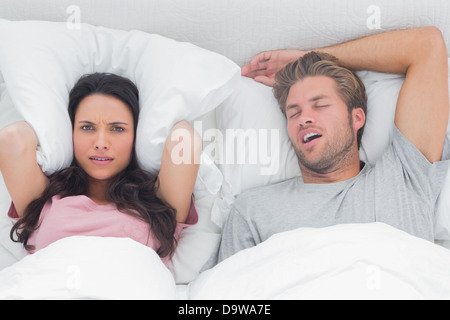 Woman annoyed by the snoring of her husband Stock Photo