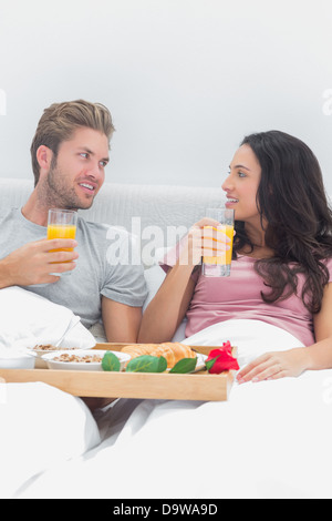 Cheerful couple having breakfast in bed Stock Photo