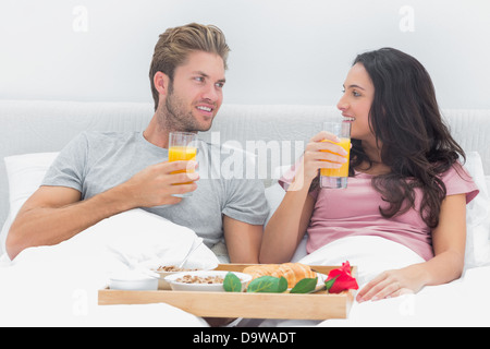 Attractive couple having breakfast in bed Stock Photo