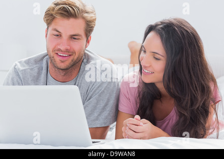 Couple using laptop in bed Stock Photo