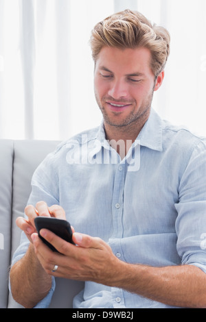 Man using his smartphone on a couch Stock Photo
