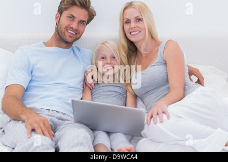 Family using a laptop in bed Stock Photo