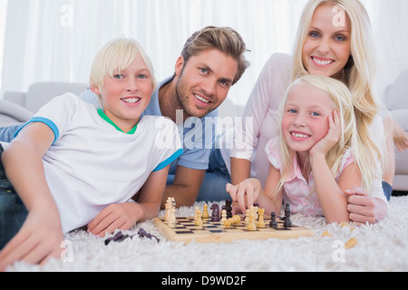 Smiling family playing chess together Stock Photo