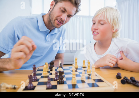 Father and his son playing chess together Stock Photo