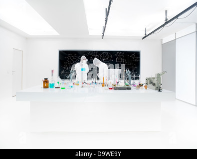 Two lab technicians working in a laboratory with vials wearing masks. Stock Photo