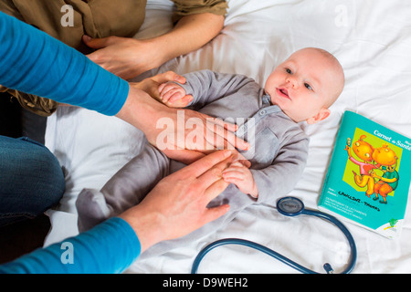 Doctor palpating the abdomen of a 5-month-old baby boy Stock Photo