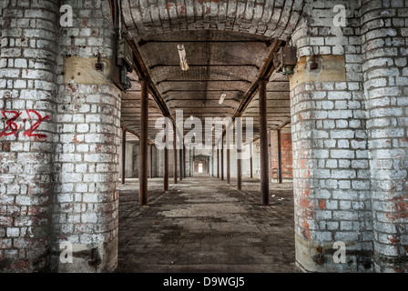 Abandoned Victorian warehouse interior with rusting iron pillars. Stock Photo