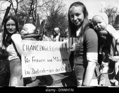 Two women having their babies on their back demonstrate with a poster saying 'Equal opportunities for women and girls in companies and universities' for equal rights at the 1st of May demonstration in 1973 in Nuremberg. Stock Photo