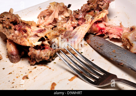 Left-over bone after a meal / knife and fork Stock Photo