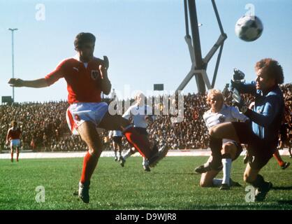 Austrian forward Hans Krankl lifts the ball over goalkeeper Sepp Maier to score the 2-2 equalizer to the dismay of his German opponents Rolf Ruessmann (2nd from right) and Berti Vogts (3rd from right) during the 1978 World Cup in Cordoba, Argentina on 21 June 1978. In the end the Austrian national team would even go on to win the World Cup second round game by a final score of 3-2 scored by Krankl. However, they would still be eliminated from the competition just like the Germany. Stock Photo