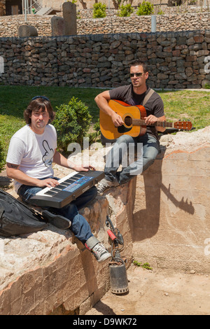 young men playing music in summer shine outside Stock Photo