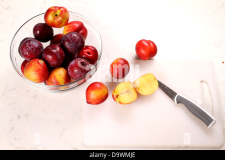 Cutting Nectarines and Plums on the kitchen table Stock Photo