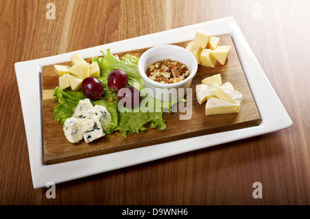 Various types of cheese on wooden platter Stock Photo