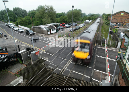 A Birmingham to Leicester train passing over a level crossing at