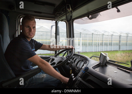 Driver in the interior of his DAF truck cabin driving through a horticulture area Stock Photo