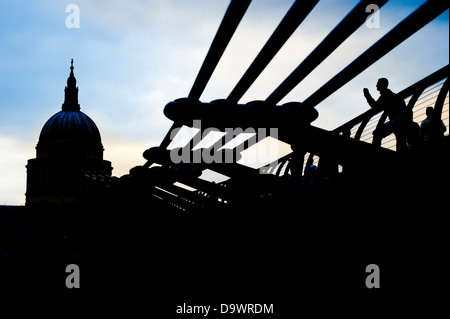 Dramatic back lit view of Saint Paul's Cathedral and the Millennium Bridge over the River Thames, In London, England, UK. Stock Photo