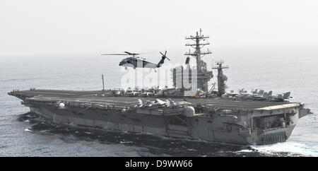A US Navy MH-60S Sea Hawk helicopter flies by the aircraft carrier USS Nimitz June 26, 2013 operating in the Gulf of Oman. Stock Photo