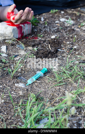 Bloody hand and syringe near it. Crime scene Stock Photo